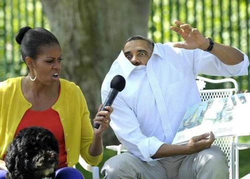 Then-President Obama and his wife Michelle Obama read Where The Wild Things Are to children. Barack is really playing it up for the kids. His head is in his shirt and his eyes are wide.