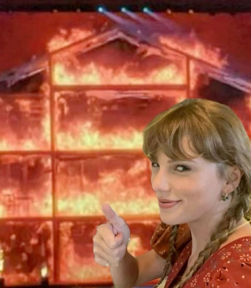 taylor swift with double braids wearing a orange flower dress with a thumbs up and a smile. she is smiling in front of the burning 1989 era house during the eras tour. 