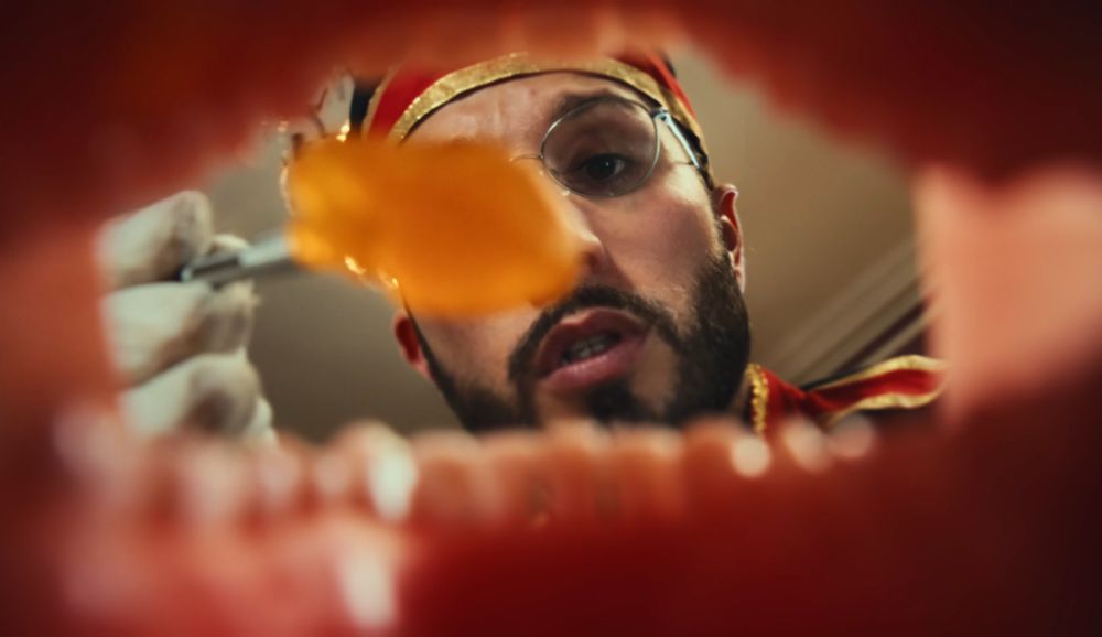 inside of mouth as bbno$ is taking a orange thing out of it 