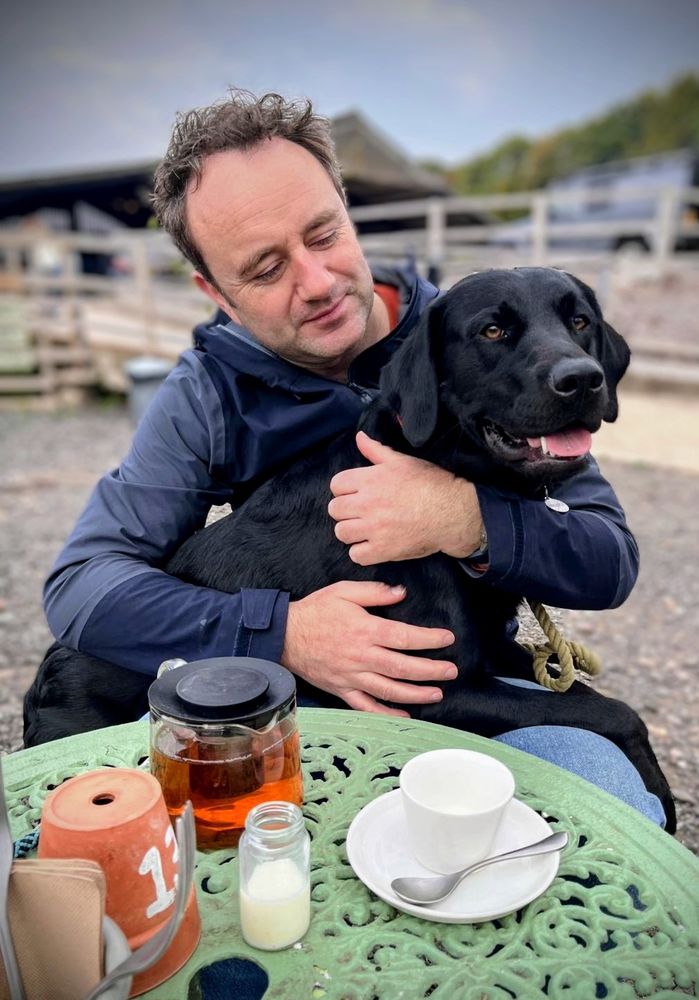 Danny and his Labrador Moose at a cafe table 