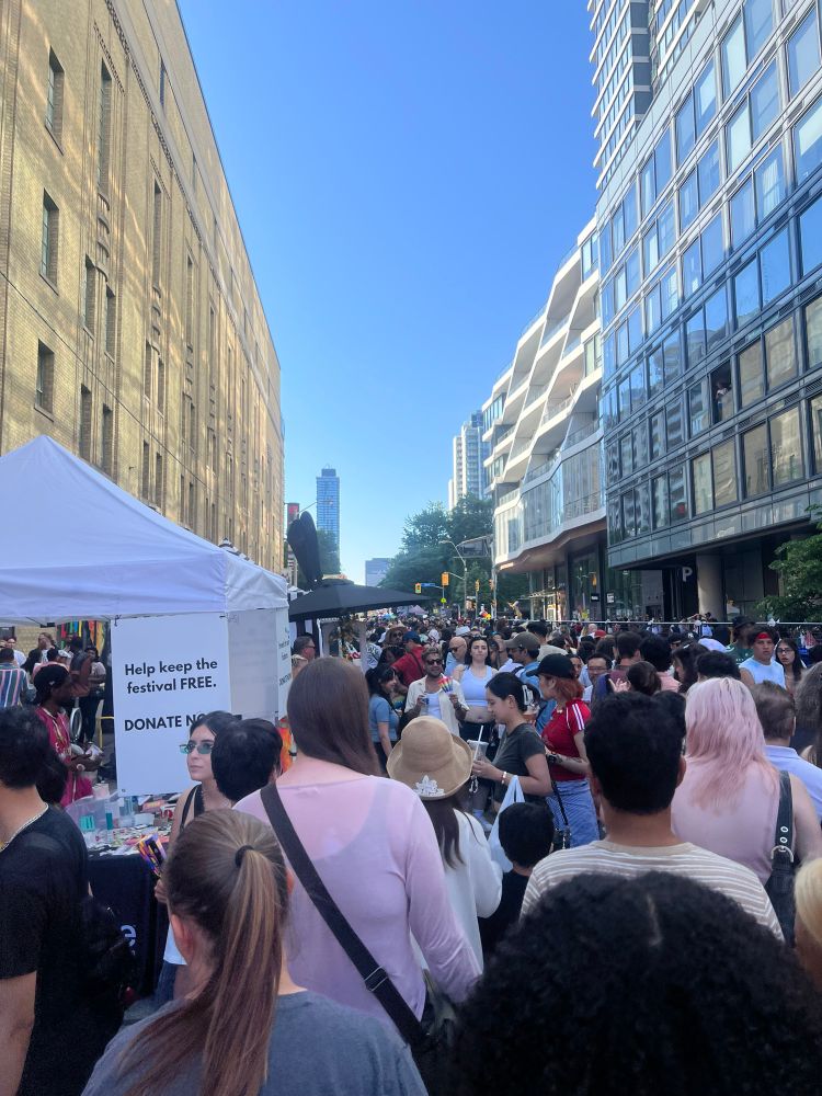 A pic of a crowded street festival with vendors.