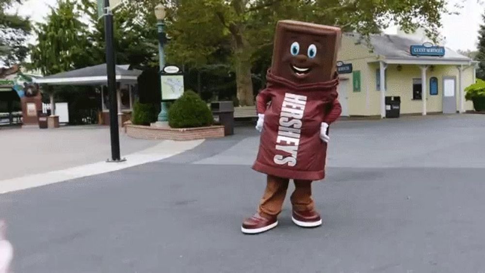 a hershey 's mascot is standing on a sidewalk