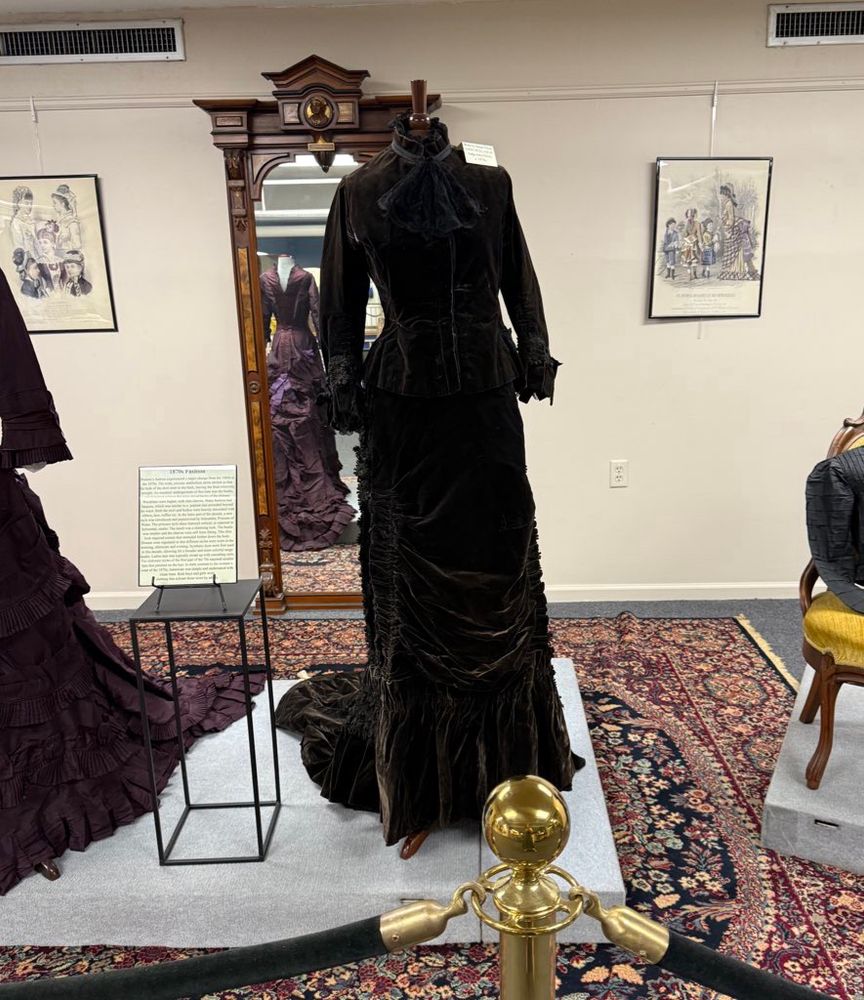 A black velvet or velour dress from the 1870s