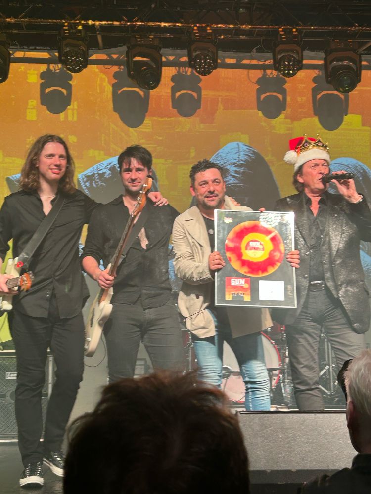 Scottish rockers Gun being presented with an award for their new album, at the Glasgow Barrowlands.