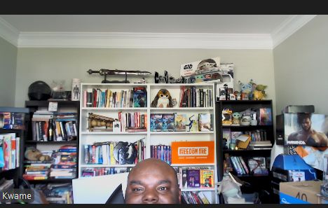 Virtual Kwame can barely be seen in his messy office