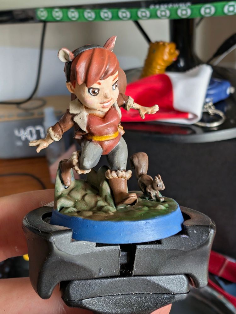 Squirrel girl miniature from Marvel United. She's running with Tippy toe the squirrel (her pet).