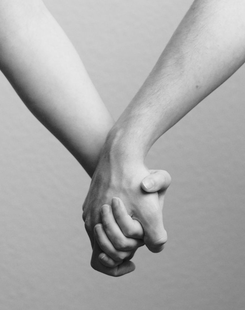 Zwei sich haltende Hände in Schwarz-Weiß.