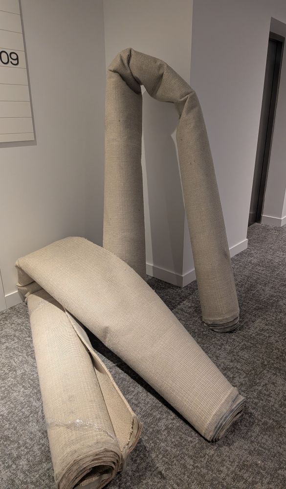 Two huge carpets bent against a wall in an apartment hallway