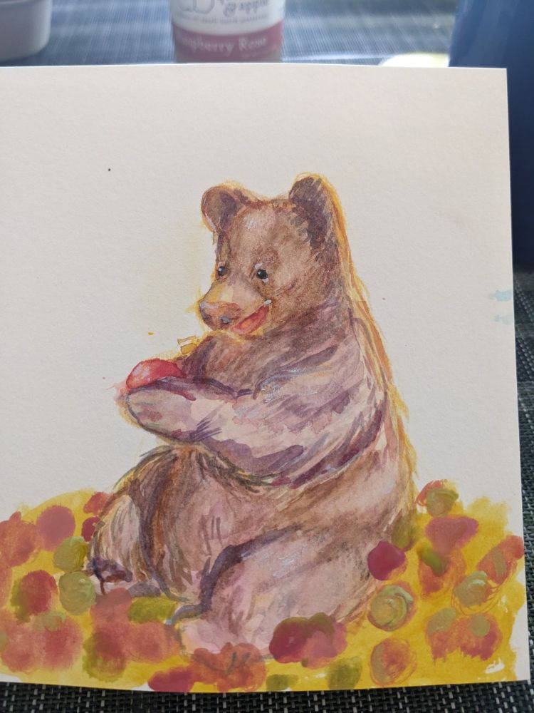 Watercolor progress painting bear sitting in a field holding an apple