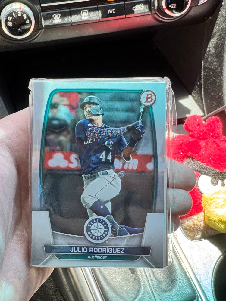 A picture of a baseball card pack with the cover athlete being Julio Rodriguez. A red Angry Bird Plushie can be seen off to the right, that’s my boy Todd