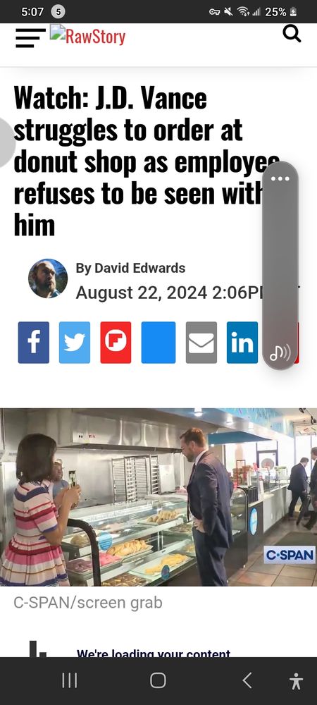 JD Vance in front of a counter in a donut store.Lady in striped dress holding a microphone. Behind the counter an employee looking at Vance.