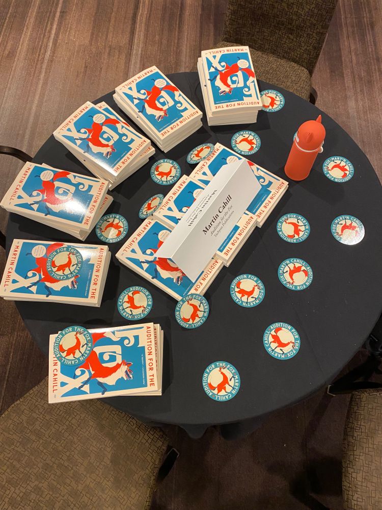 A table full of books of Marty’s and stickers making it look like chickenpox