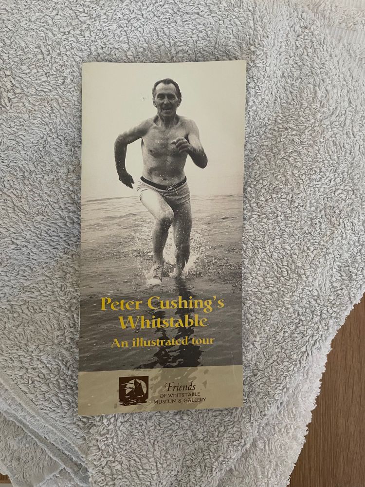A pamphlet called ‘Peter Cushing’s Whitstable’: a photograph of a bare chested Peter Cushing running through water on the cover.
