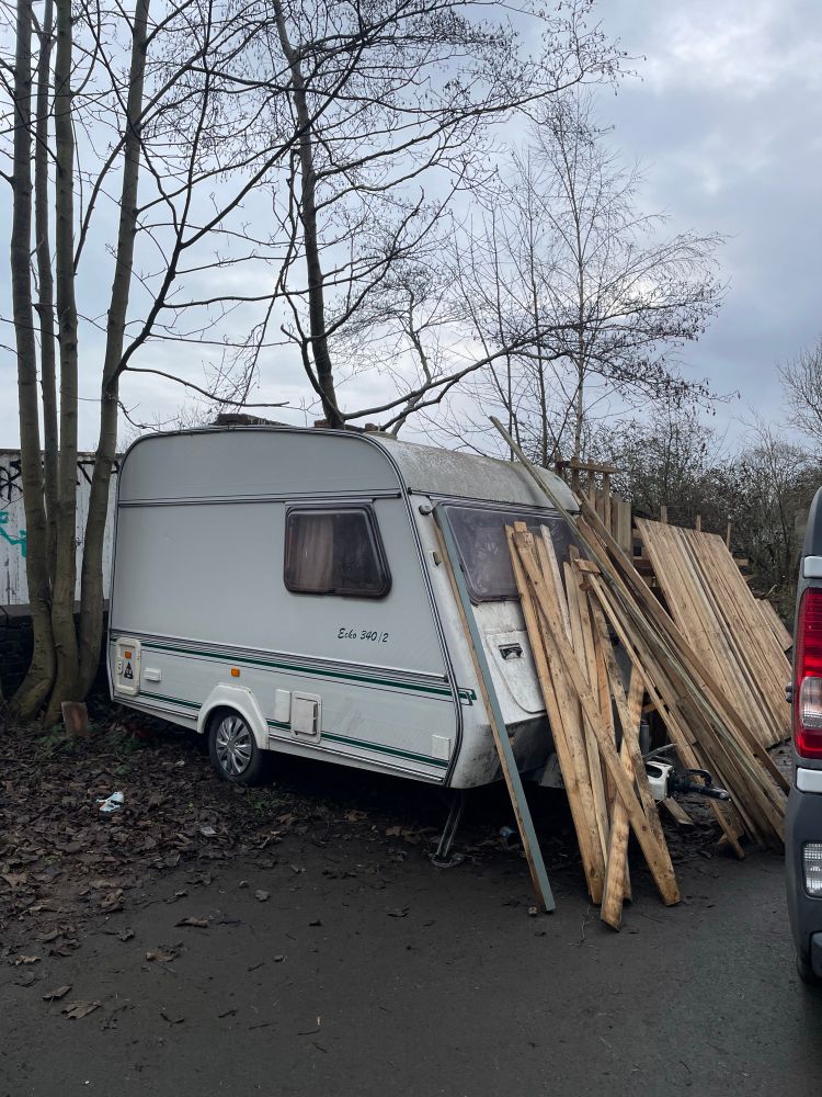 A caravan with lengths of wood resting against it