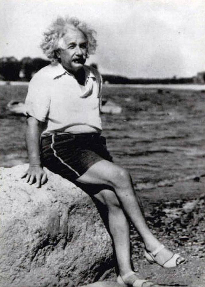 Einstein serving cunty vibes in a historical black-and-white photo. Rocking some fabulous sandals and striking a top-tier beauty pageant pose, giving us timeless sass on the beach.