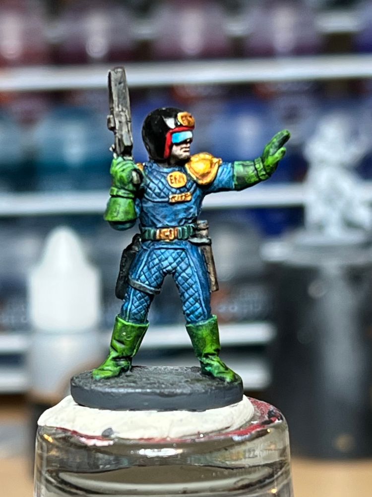 Cyberpunk cop mini painted in the blue, green and gold colours of Judge Dredd