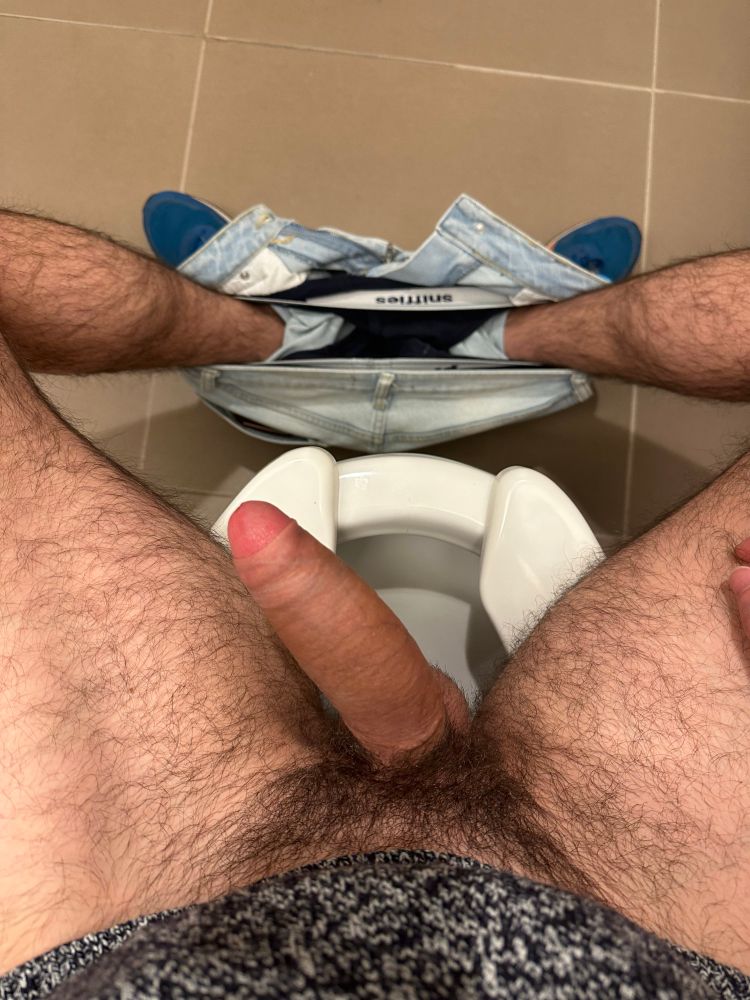 Me sitting down on a toilet in a public bathroom, my uncut cock is hard. My jeans are around my ankles and you can make out my Sniffies underwear 
