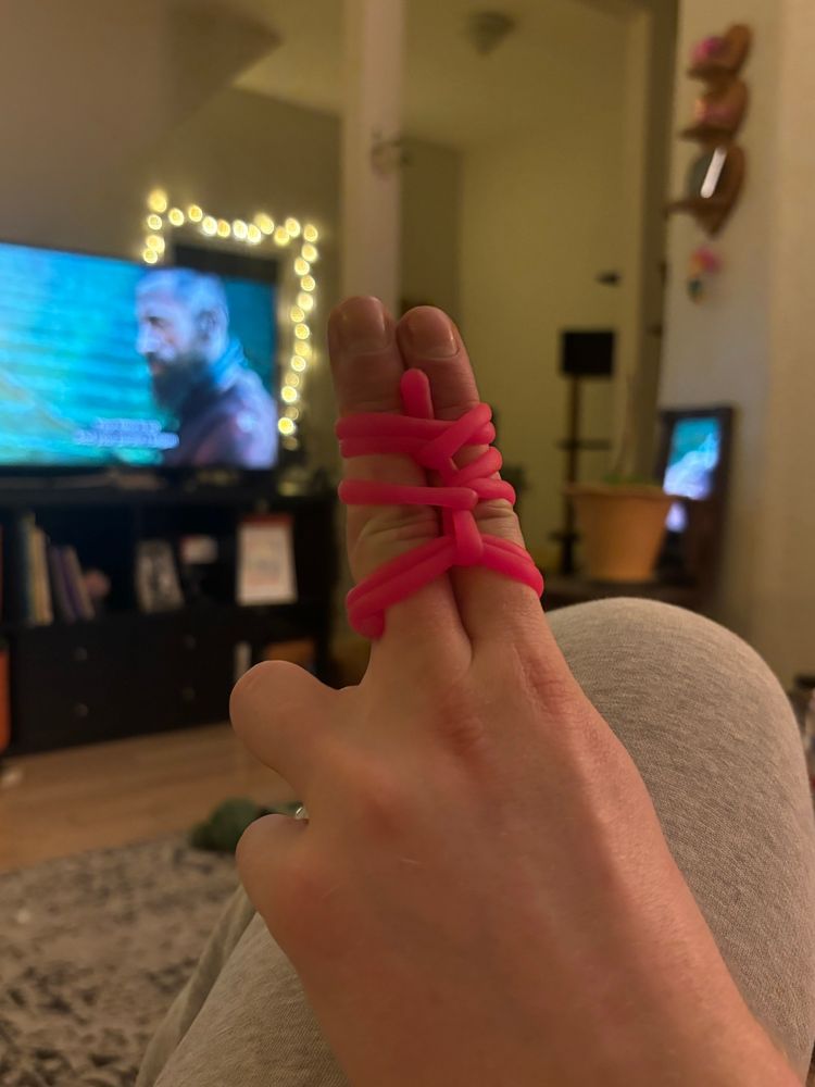 fingers tied together with fidget toy
