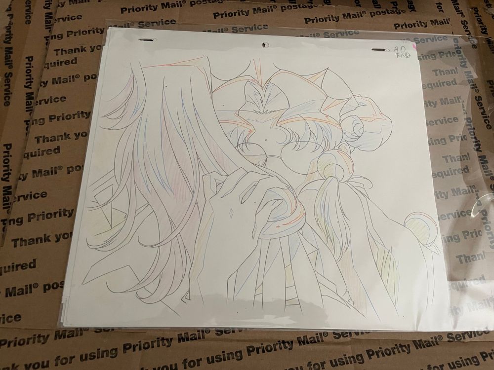 douga animation paper showing the frame of pivotal moment of Revolutionary Girl Utena episode 38, when Anthy is embracing Utena from behind, her left hand coming up to cradle Utena’s shoulder and her face pressed against Utena’s back. her eyes aren’t shown in the drawing because they were animated on separate frames
