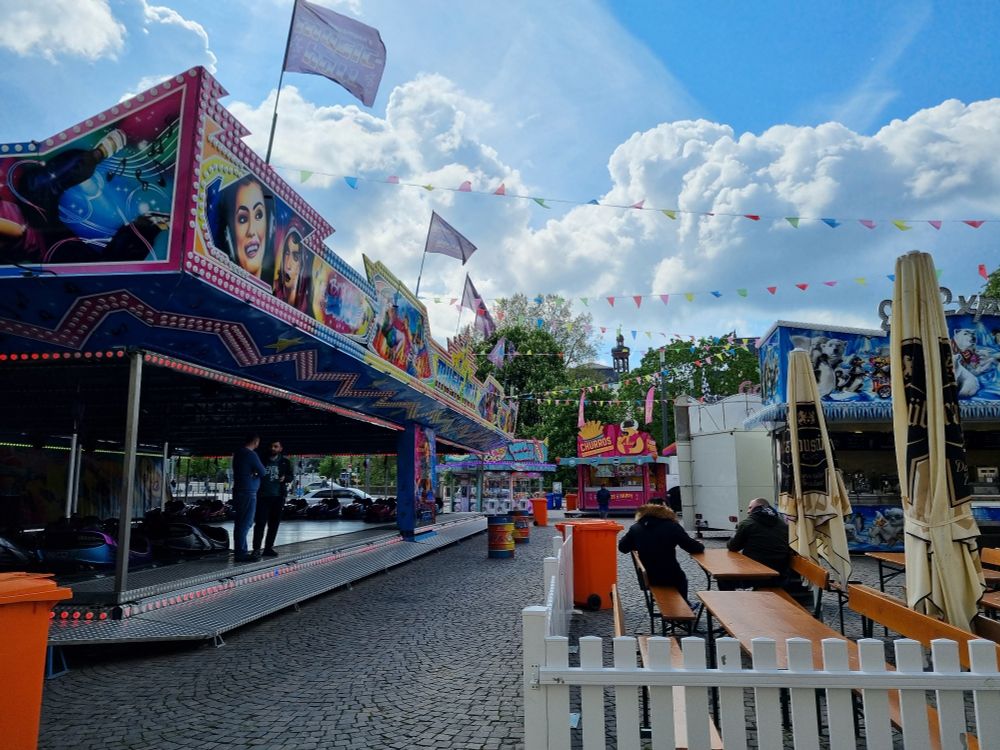Autoscooter und Bierbänke, im Hintergrund weitere Buden.