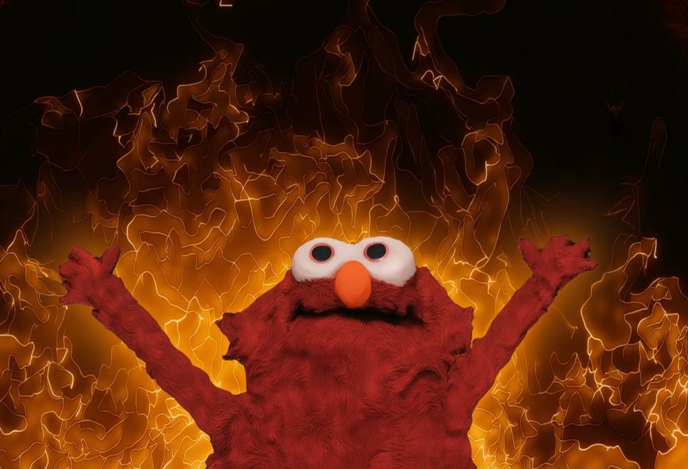 Meme - Sesame Street's Elmo with arms up and rapturous against a backdrop of flames.