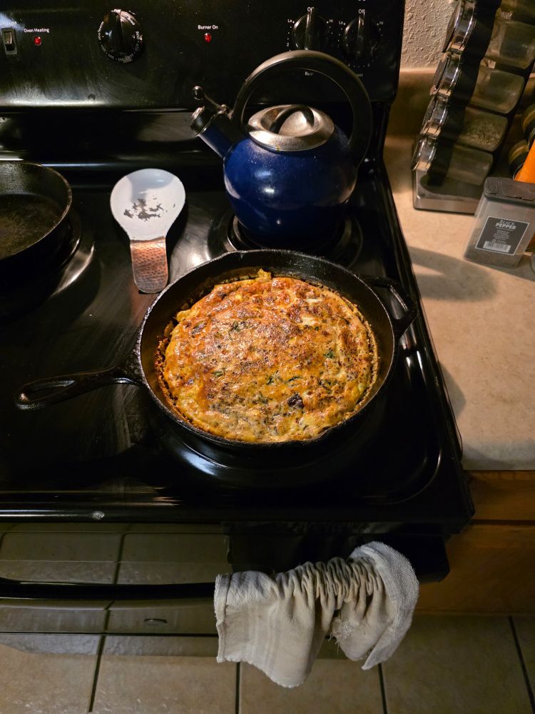 A fritatta, nicely browned on the top in a cast iron skillet, freshly pulled from the oven