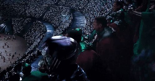 a crowd of people sitting in a stadium watching a game .