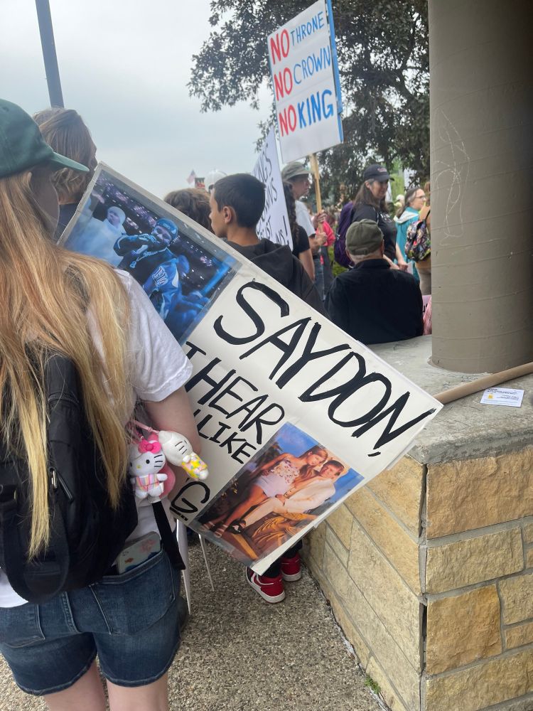 Image of protester holding sign with sn image of Donald And a pre teen Ivanka Trump sitting on his lap with a caption “Say Don, I hear you like them young.” Another photo shows a photo of Kendrick Lamar at the super bowl performance, showing him walking and smiling directly at the camera.