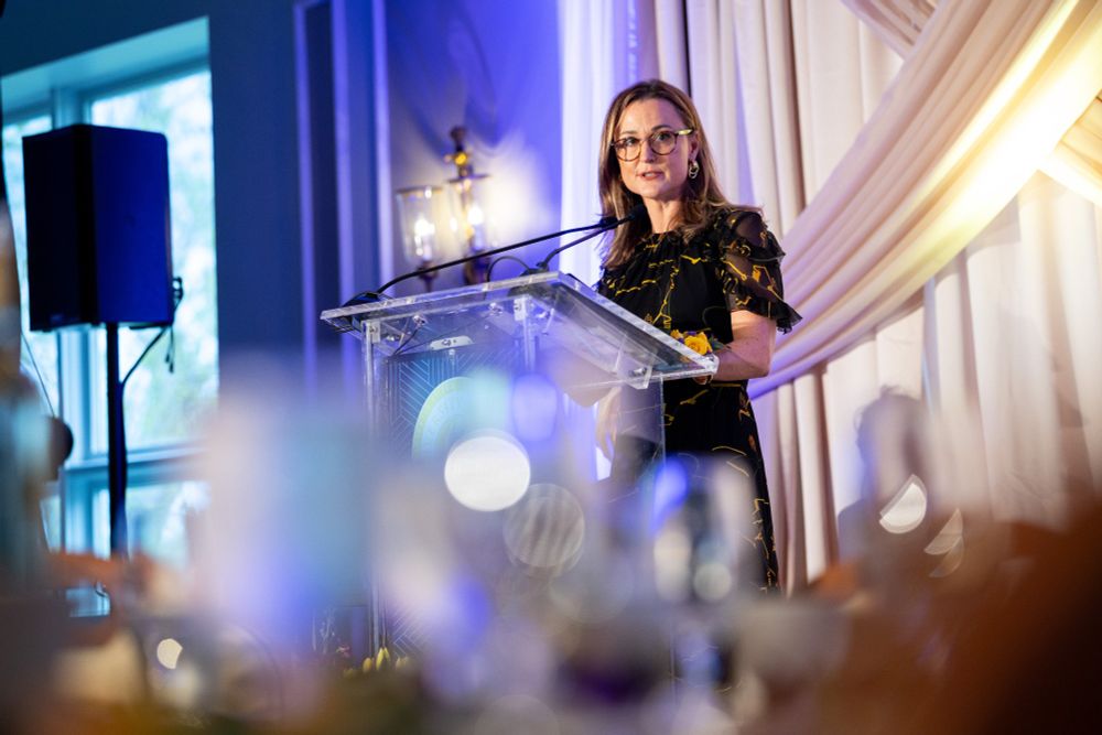 A woman delivers award acceptance remarks at a podium.
