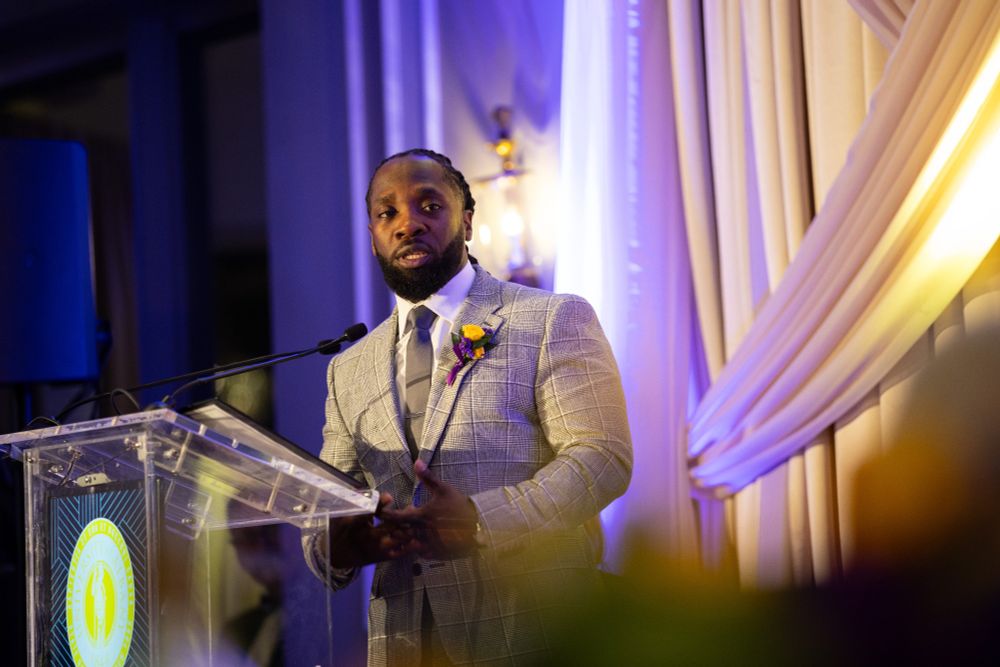 A man delivers award acceptance remarks at a podium.
