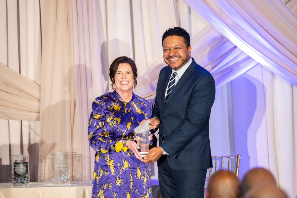 A woman receives an award on a stage.