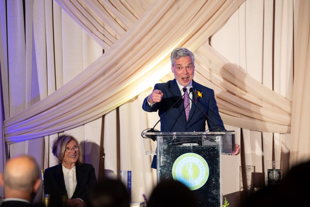 A man delivers award acceptance remarks at a podium.