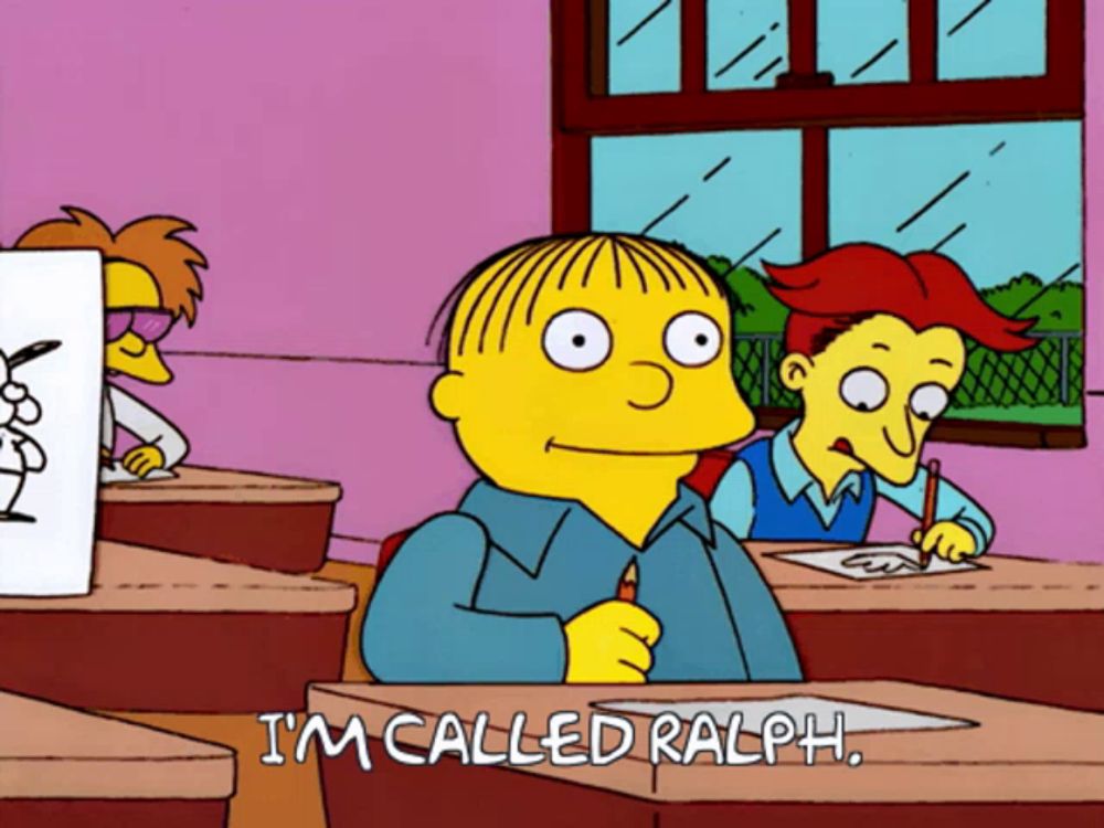 a cartoon of ralph from the simpsons is sitting at a desk