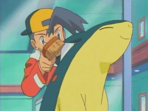 a boy in a yellow hat is holding a yellow and black pokemon