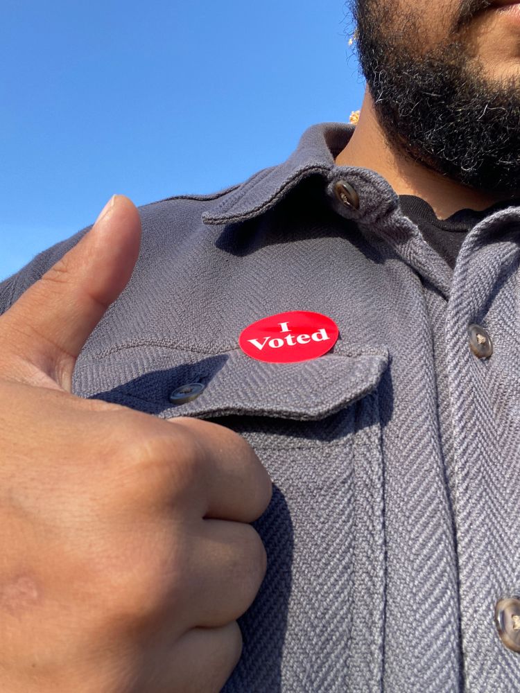 An “I Voted” sticker on a blue jacket, with Jeff’s ashy hands giving a thumbs-up.