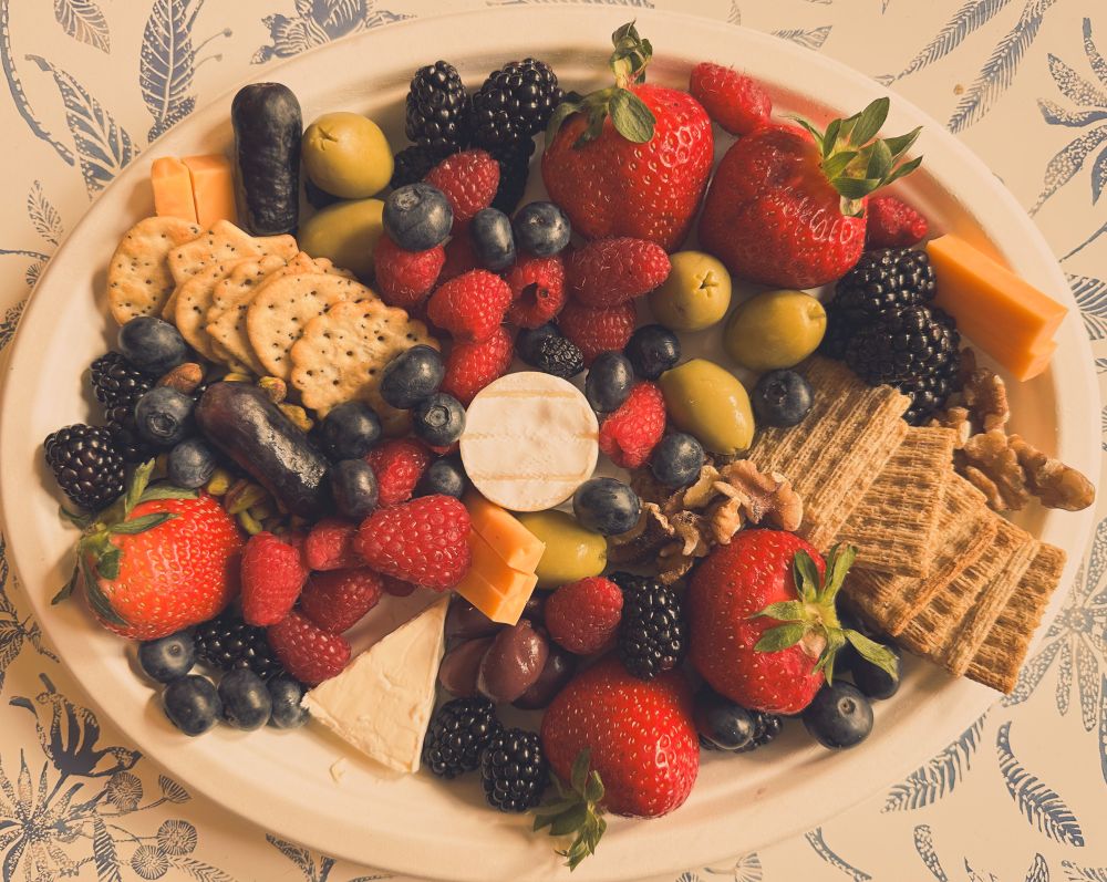 Fruit cheese and crackers arranged on a plate but with a vintage filter 