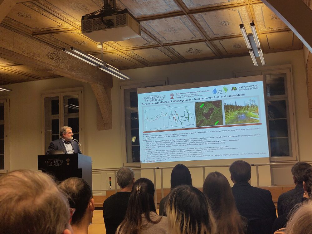 Presentation of the sustainability prize for final theses at the university of tübingen 2024. Prof. Potthast announces the winners with images of Marie Geisbusch's work in the background on a screen.
