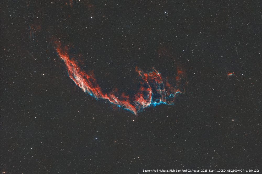 Wide image of the Eastern Veil Nebula
Thin red nebulosity with blue lower edge stretching from top left towards bottom right in a shallow bowl shape, a prominence rises up on the left hand side.
The nebula was discovered on 5 September 1784 by William Herschel.