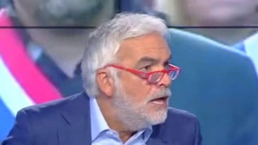 Pascal Praud, bouche semi ouverte et lunettes rouges tombantes sur le nez