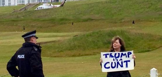 Comedian Janey Godley holding a sign saying Trump is a Cunt