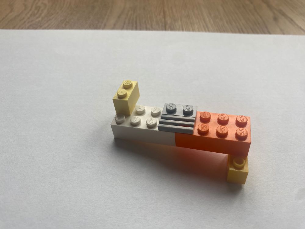 Bild einer DNA-Doppel-Helix, gebaut aus Legosteinen, gezeigt werden die verbundenen Basenpaare und teile des Zuckerrückgrats.  