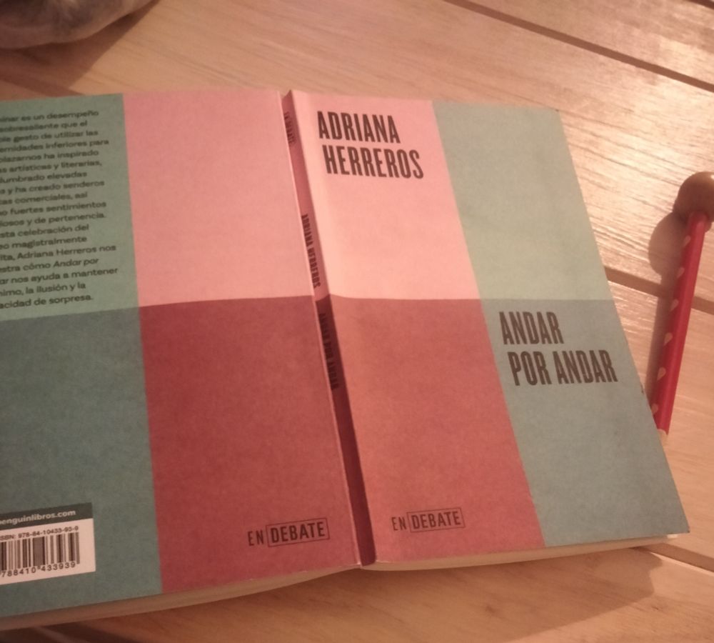 Portada del libro "Andar por andar", de Adriana Herreros, sobre una mesa de madera con un lápiz rojo y lunares amarillos al lado