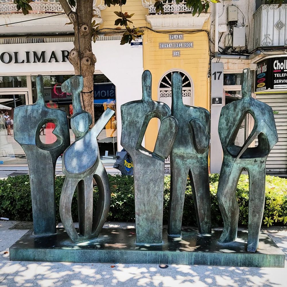Escultura Los Oficios (1999) de Elena Laverón, ubicada en la plaza de la Costa del Sol de Torremolinos, cuya ubicación ha sido cambiada en los últimos meses. La obra se encontraba en el centro de la vía peatonal y ahora se ha arrinconado en uno de sus márgenes, lo que esconde el juego de vacíos de la obra