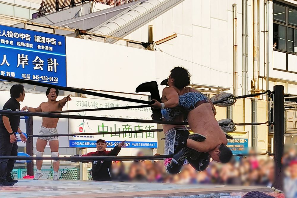 駅前の駐車場で行われたプロレス興行の写真