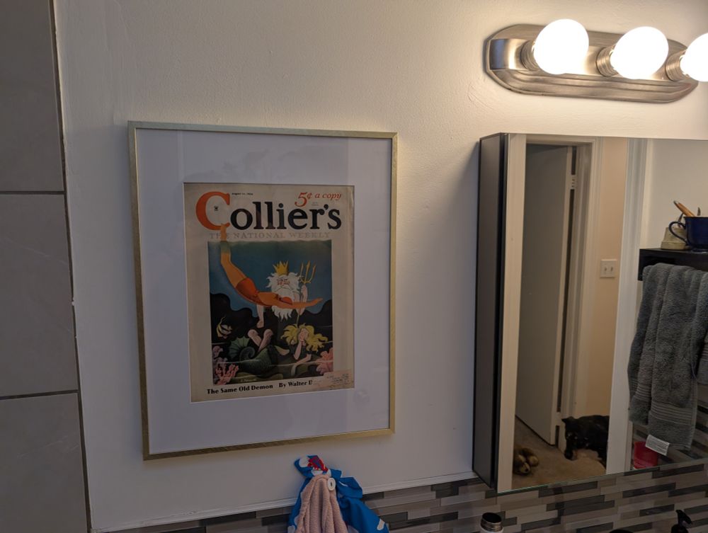 the collier's magazine, hung and framed beside the bathroom vanity