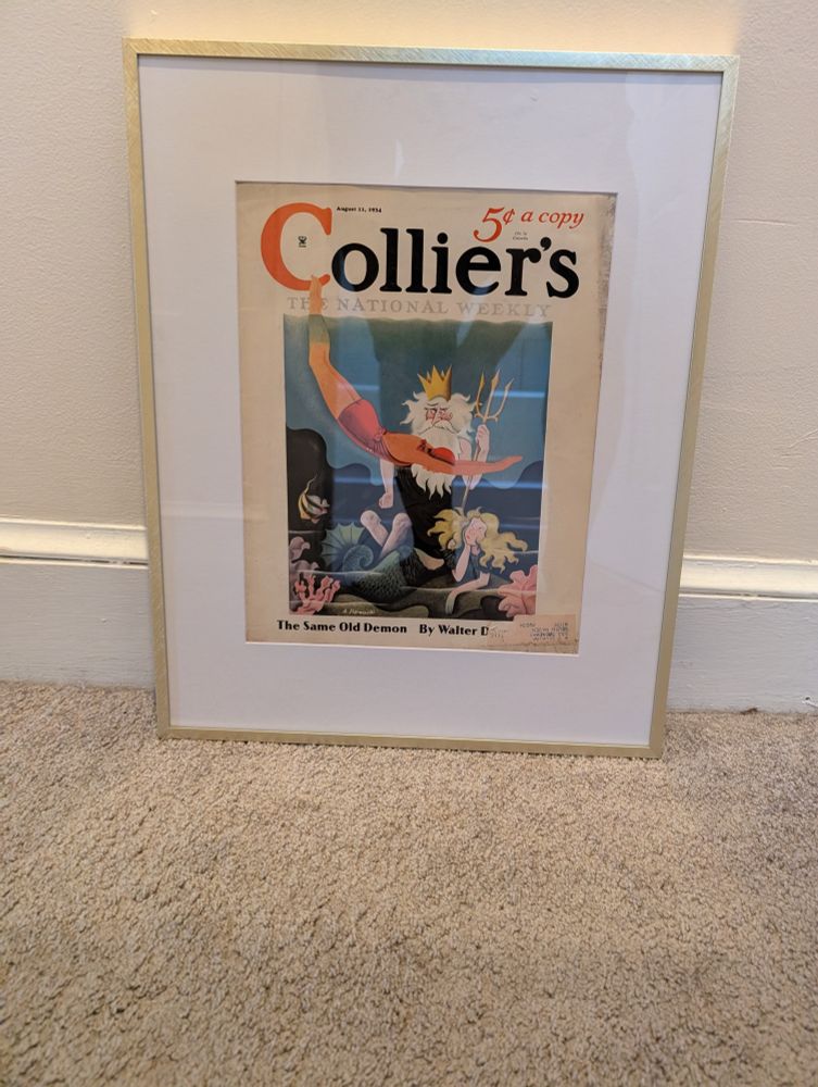 A copy of Collier's magazine from August 11th, 1934, framed in a gilt-edged frame sitting against a wall.

The cover illustration depicts a woman in an early 20th-century bathing costume diving into the middle of a conversation between grumpy old King Triton and his bored-looking mermaid daughter.