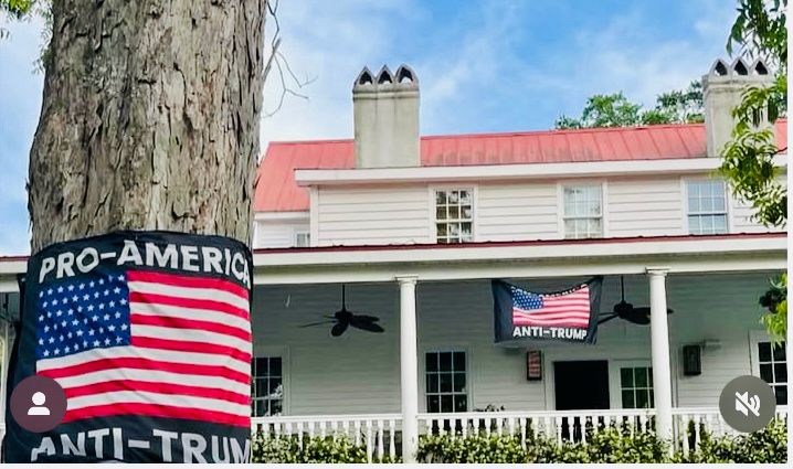 A beige house w a front porch and an American flag that says: Pro-American Anti-Trump 