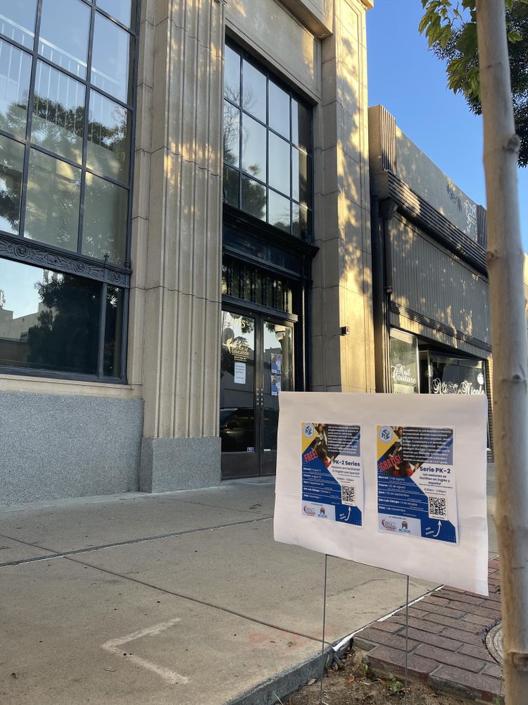 It is a warm sunny morning. The signage announcing the symposium is in front of our building.