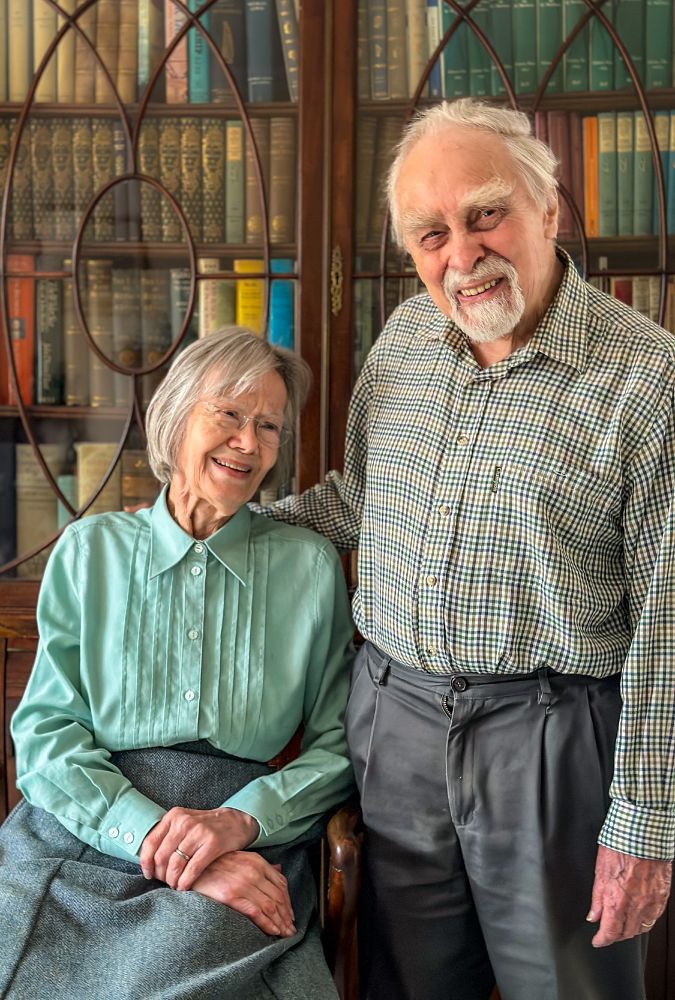 Photograph of Peter and Carolyn Hammond in front of a bookcase.