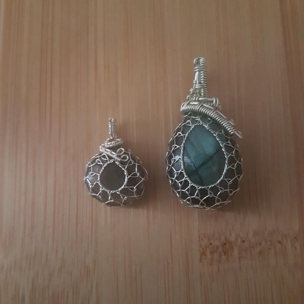 2 small labradorite drop pendants - 1st is about 1/3 the size of the other, both netted in silver wire.